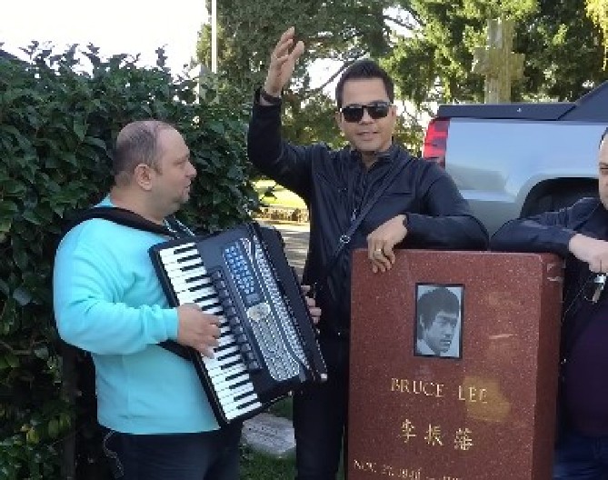 SNIMAK ZBOG KOG CEO BALKAN VRIŠTI OD SMEHA Pevač zapevao na grobu Brus Lija - pašćete sa stolice kad čujete kako mu je to palo na pamet! (VIDEO)